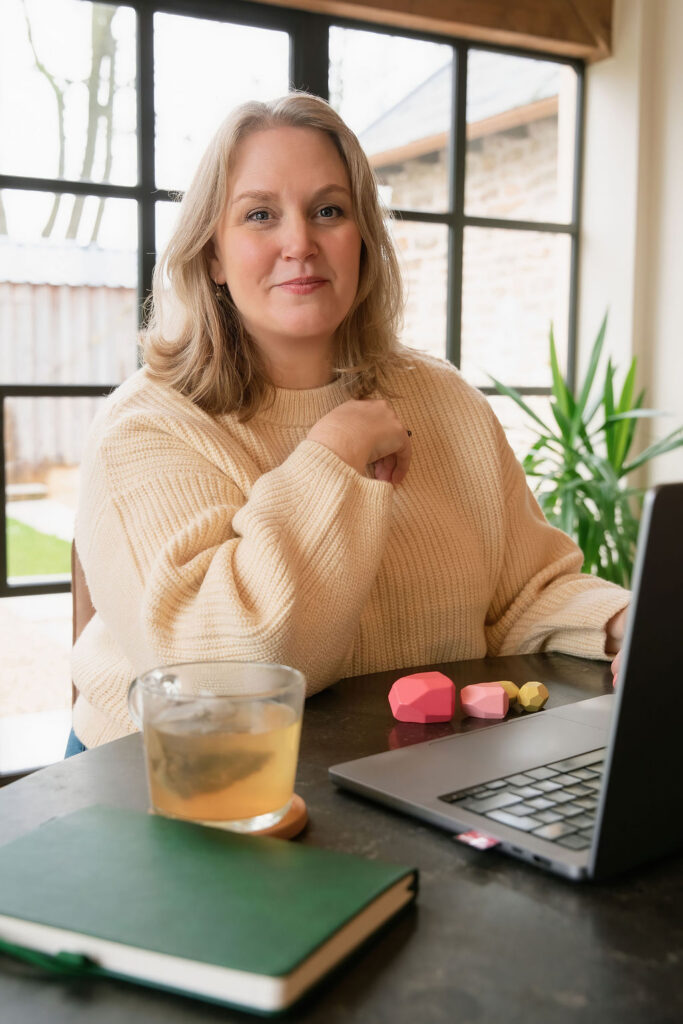 Julia sitting at a laptop looking happy